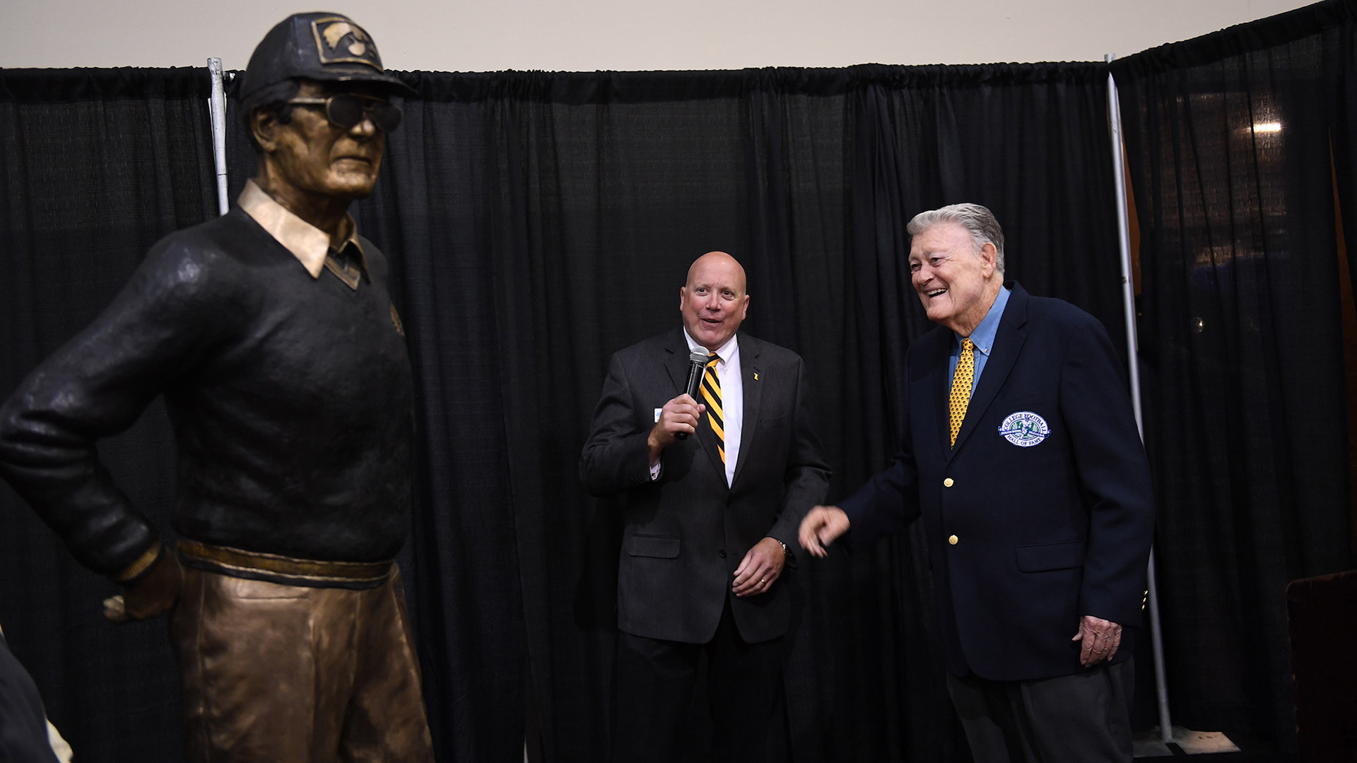 Hayden Fry looking at a statue of his likeness