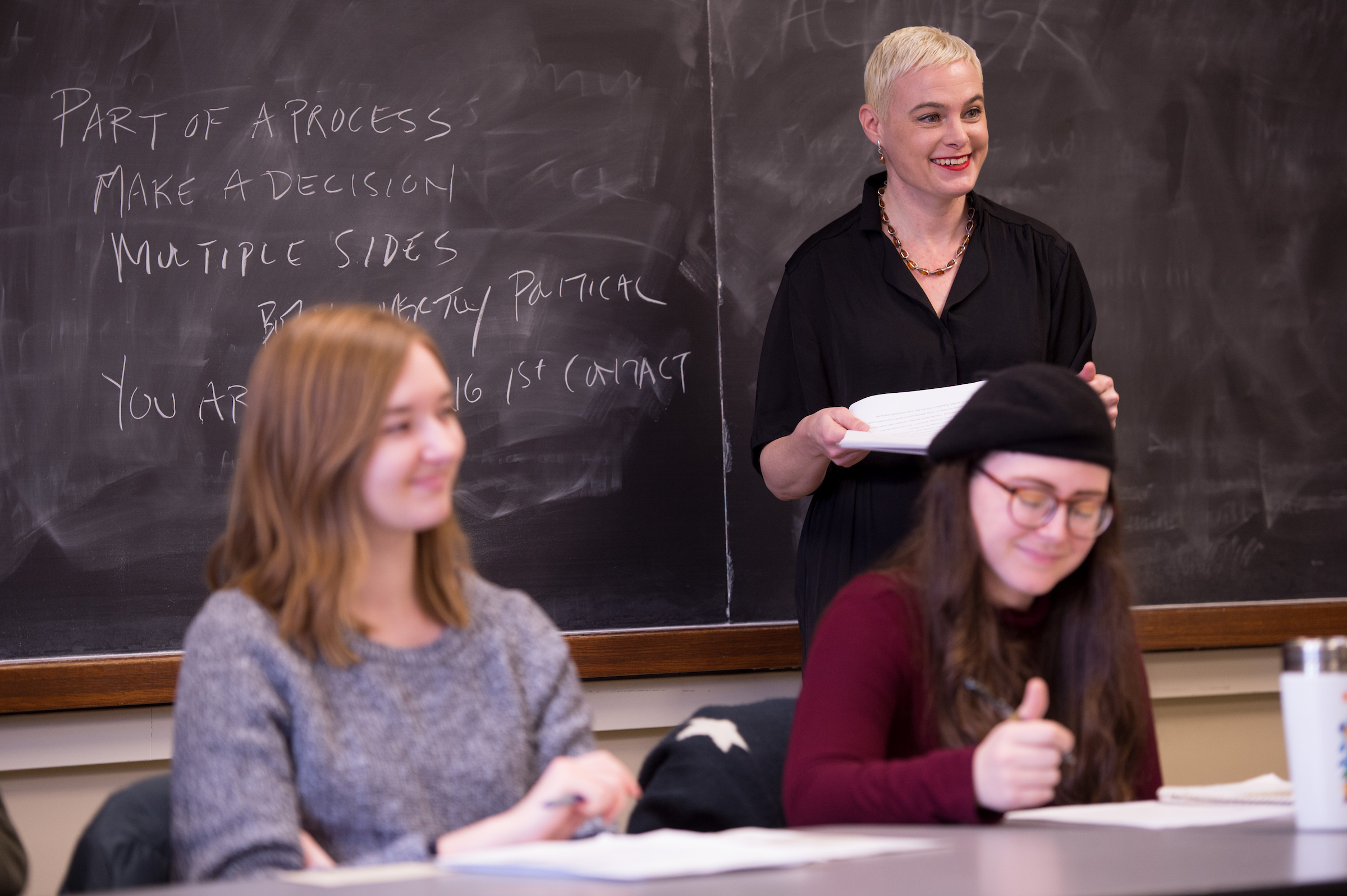 A woman teaching in front of a blackboard