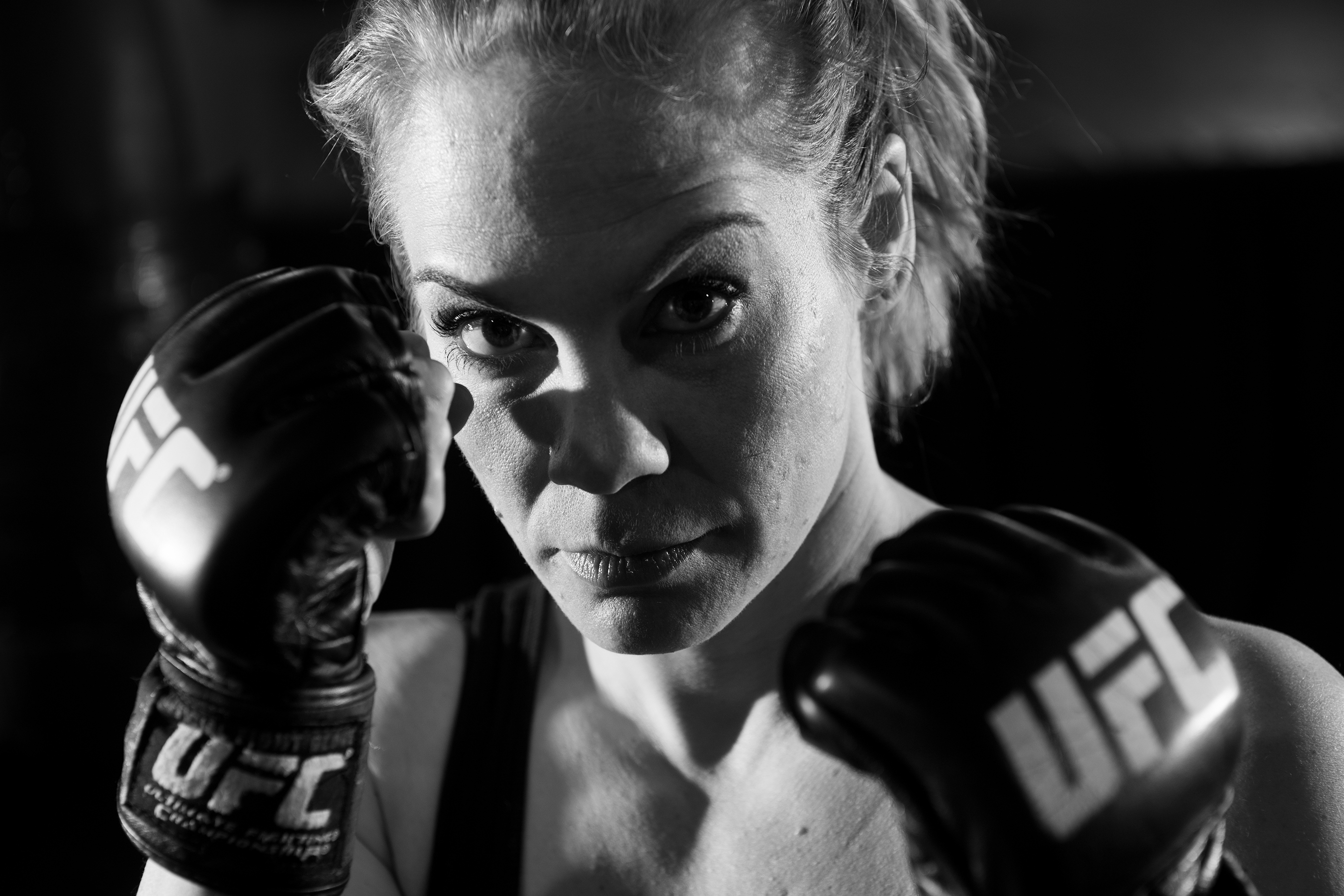 A woman holding up her fists in boxing gloves