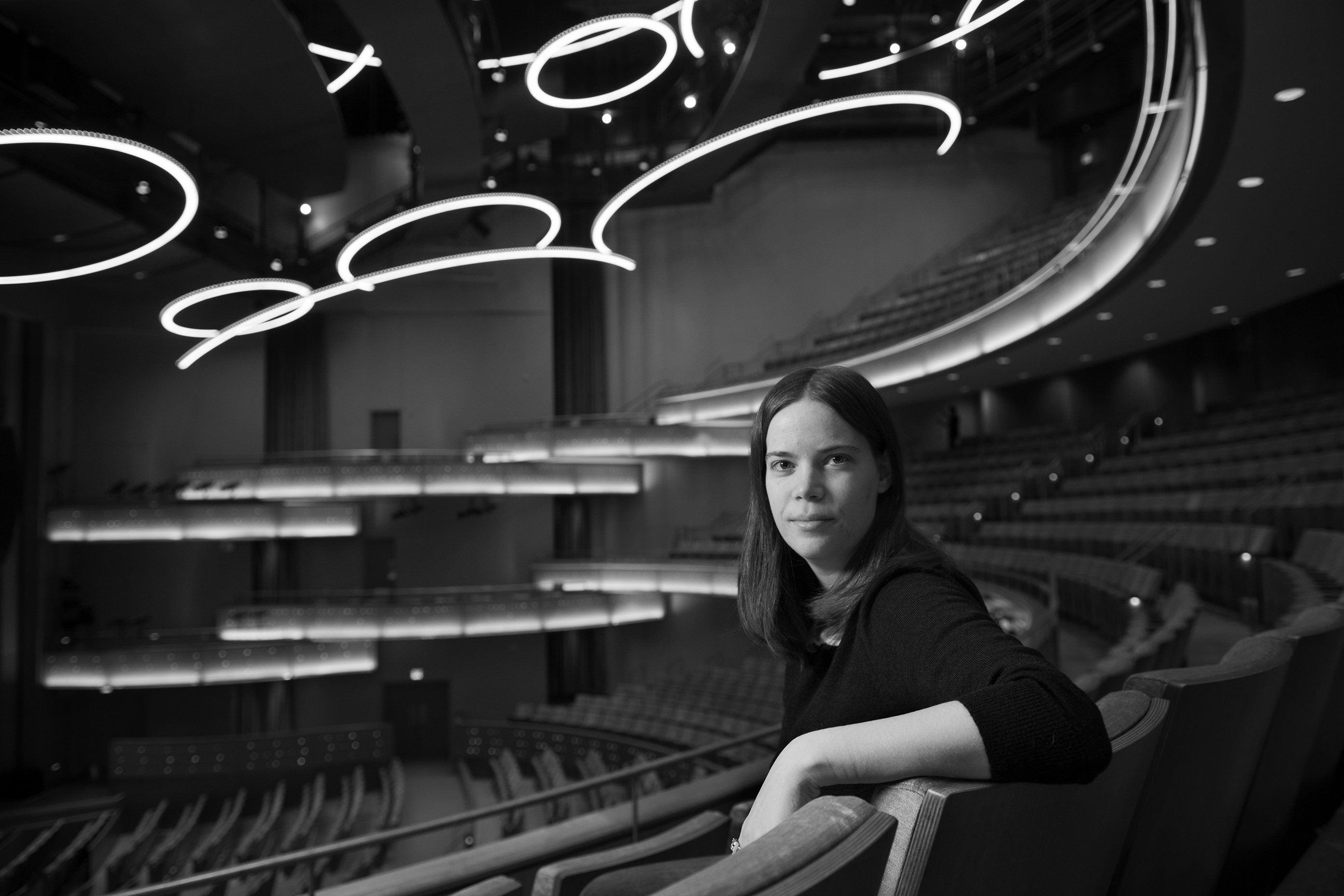 A woman sitting in an auditorium