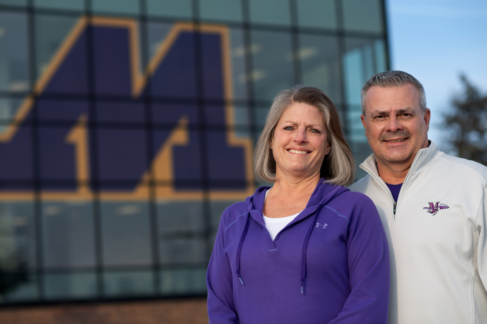 A man and a woman standing in front of a large building