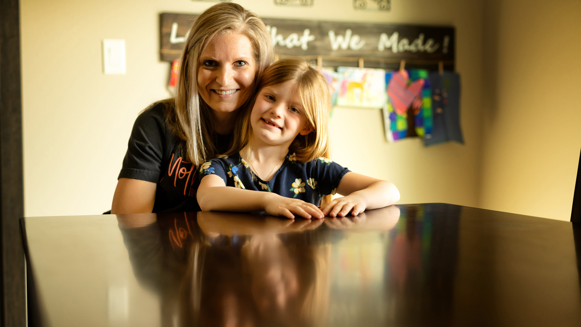 a mom and her daughter sitting at their dining room table
