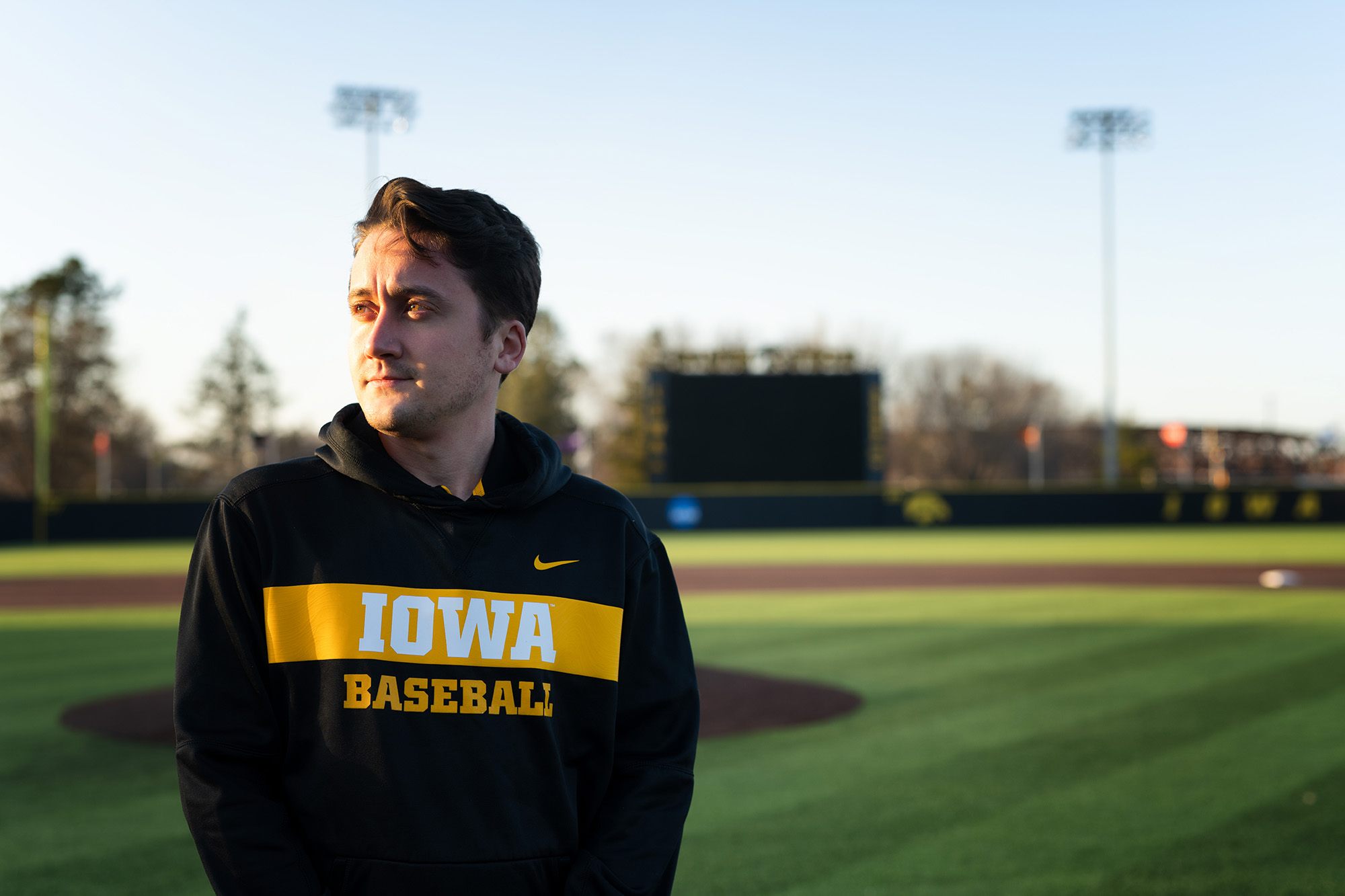 A man looking into the distance while standing on a baseball diamond