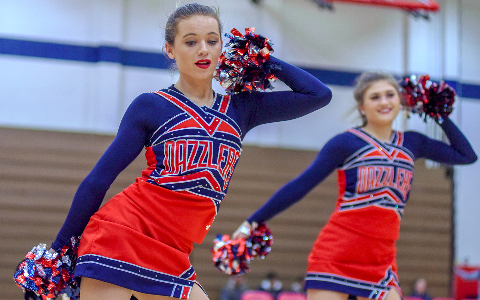 members of a dance team performing a routine in a gymnasium