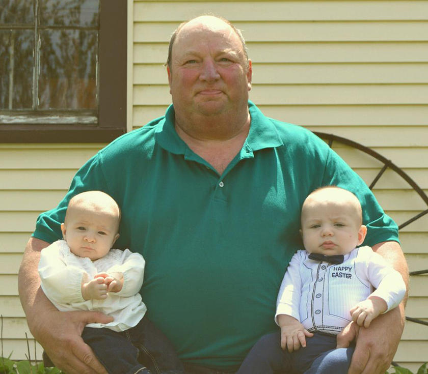 a man holding two of his grandchildren