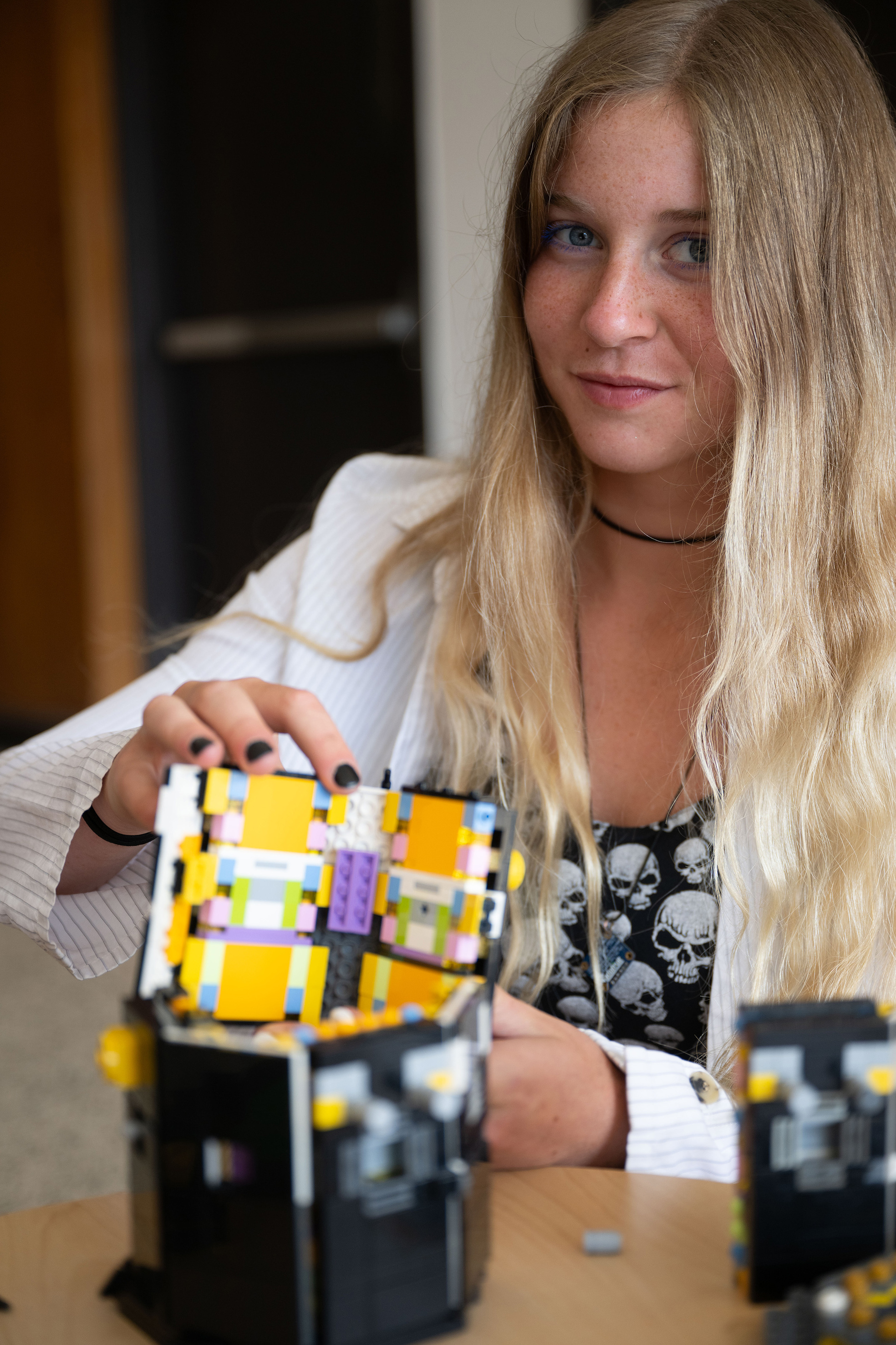 University of Iowa student Ava Reed shows off a model-sized version of the spacecraft in TRACERS built with toy bricks.
