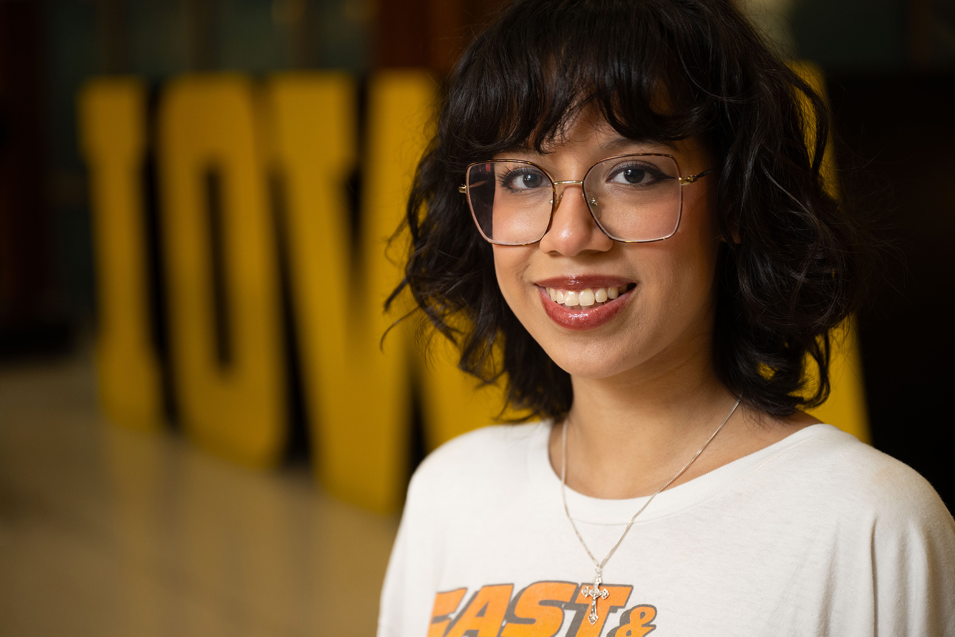 Abril Garcia Rojas standing in front of a large Block IOWA display