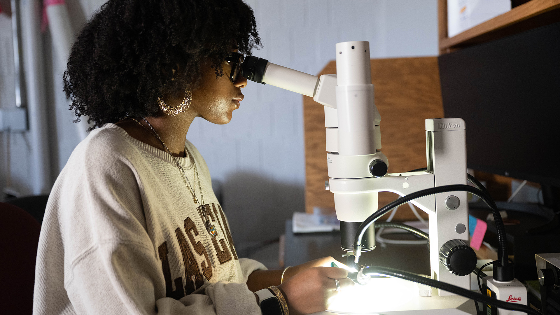 a student looking through a microscope