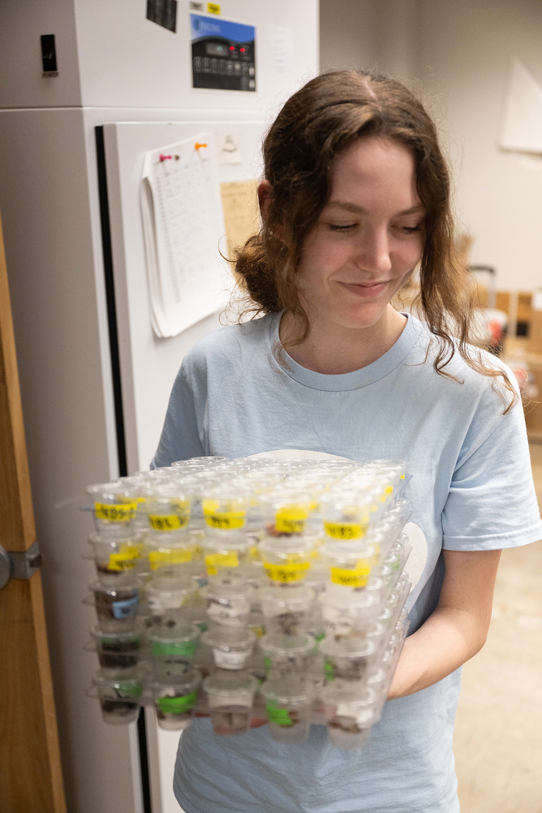 a woman carrying trays in a laboratory