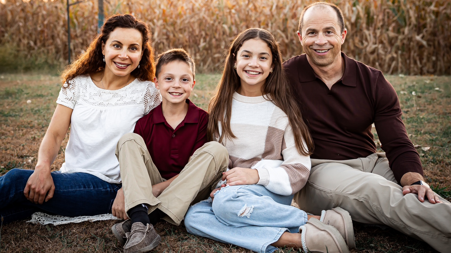 Jon Fields and his family posing for a portrait near a cornfield