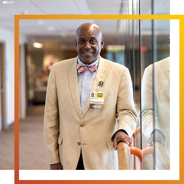 a man in a suit stands in the hallway of a health care facility