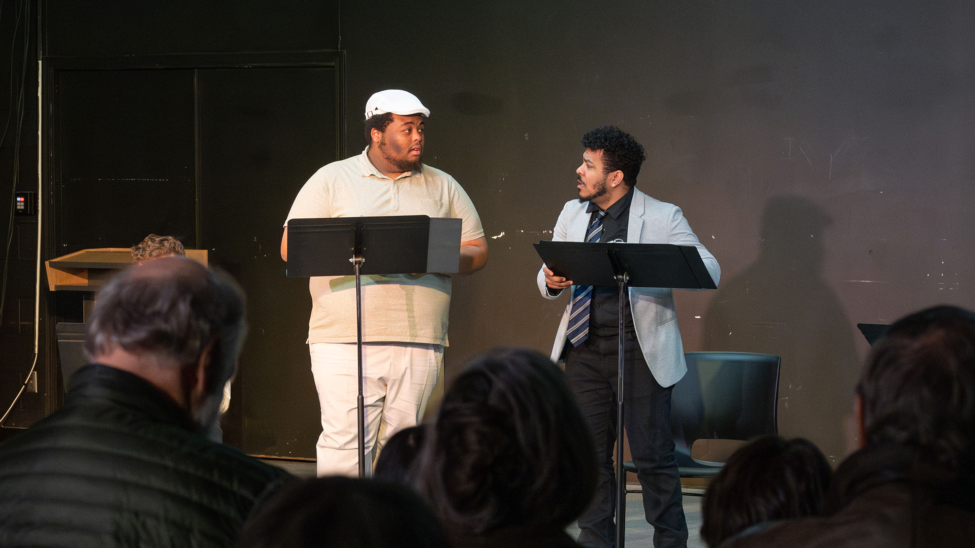 two actors perform at a staged reading of a play