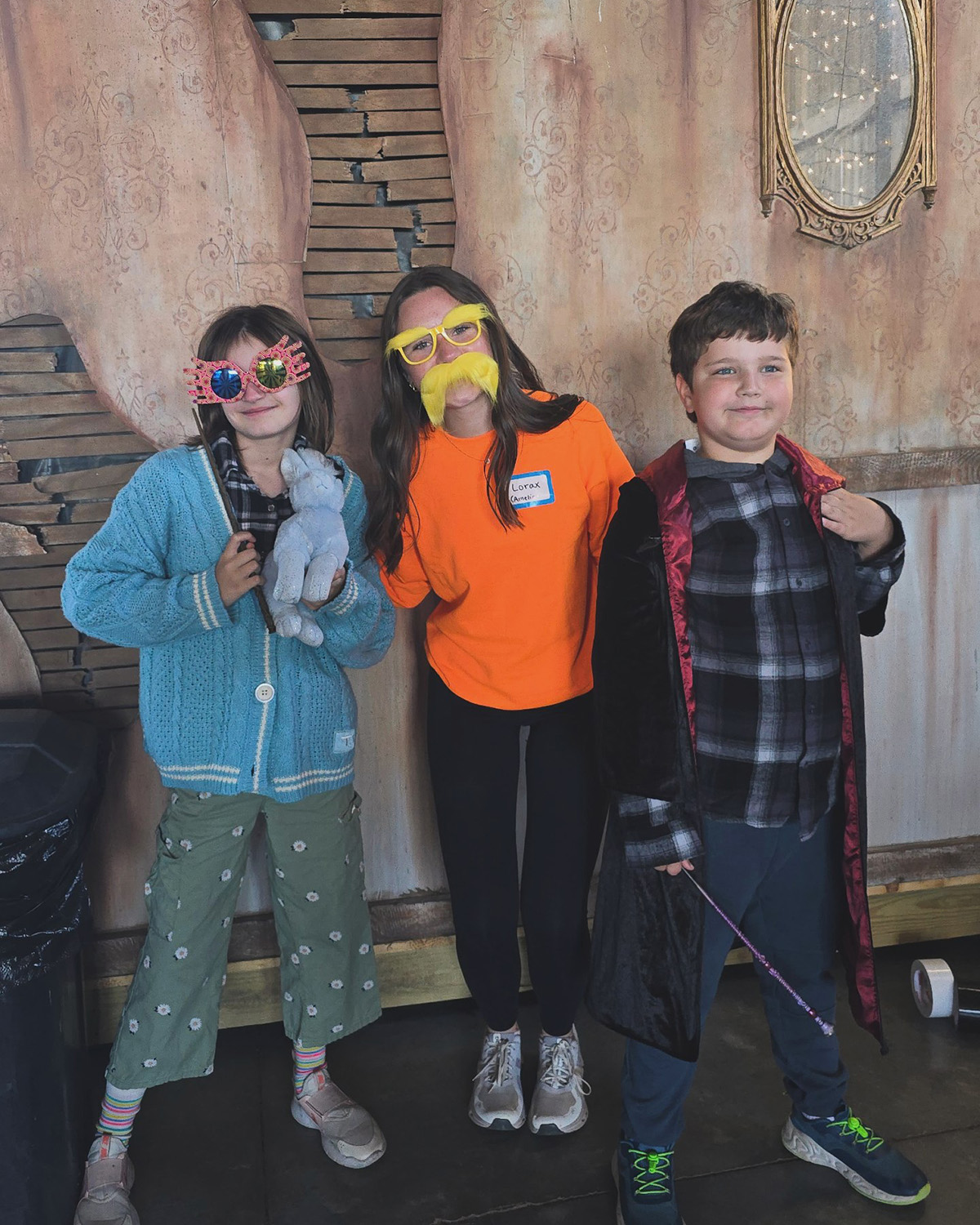 University of Iowa student Amelia Earley, dressed up to resemble The Lorax, is flanked by two siblings