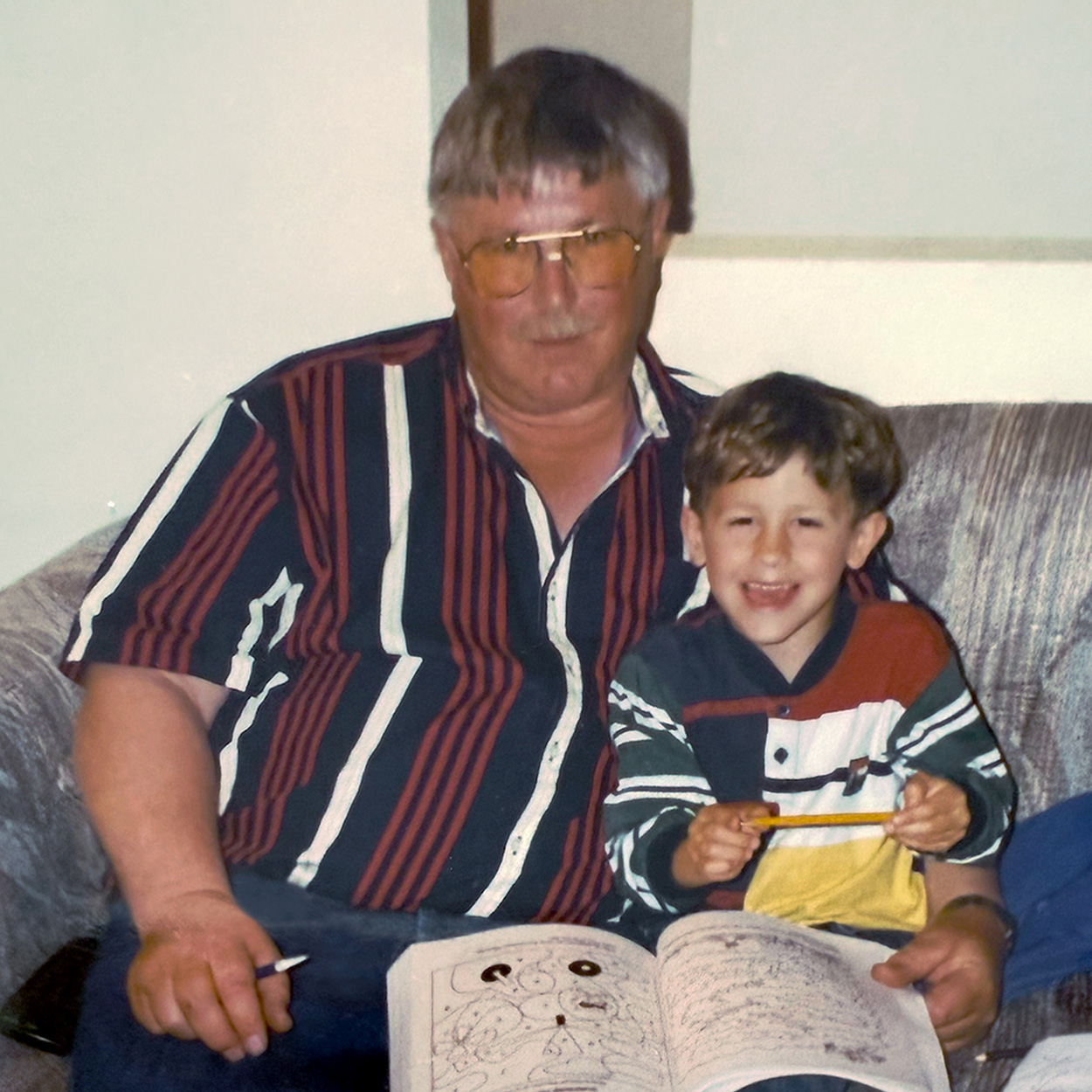 a young boy sits with his grandfather