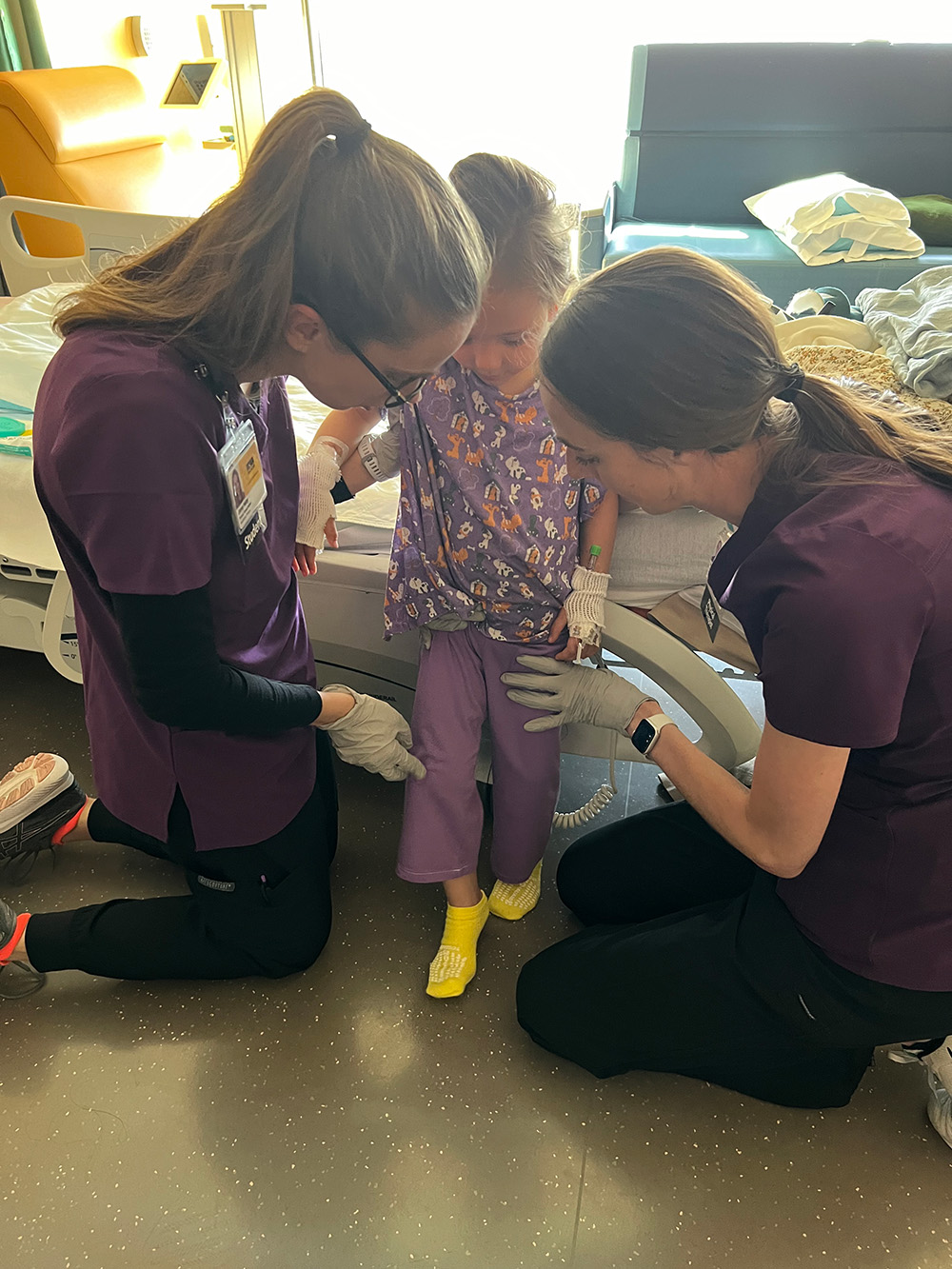 two health care professionals work with a pediatric patient