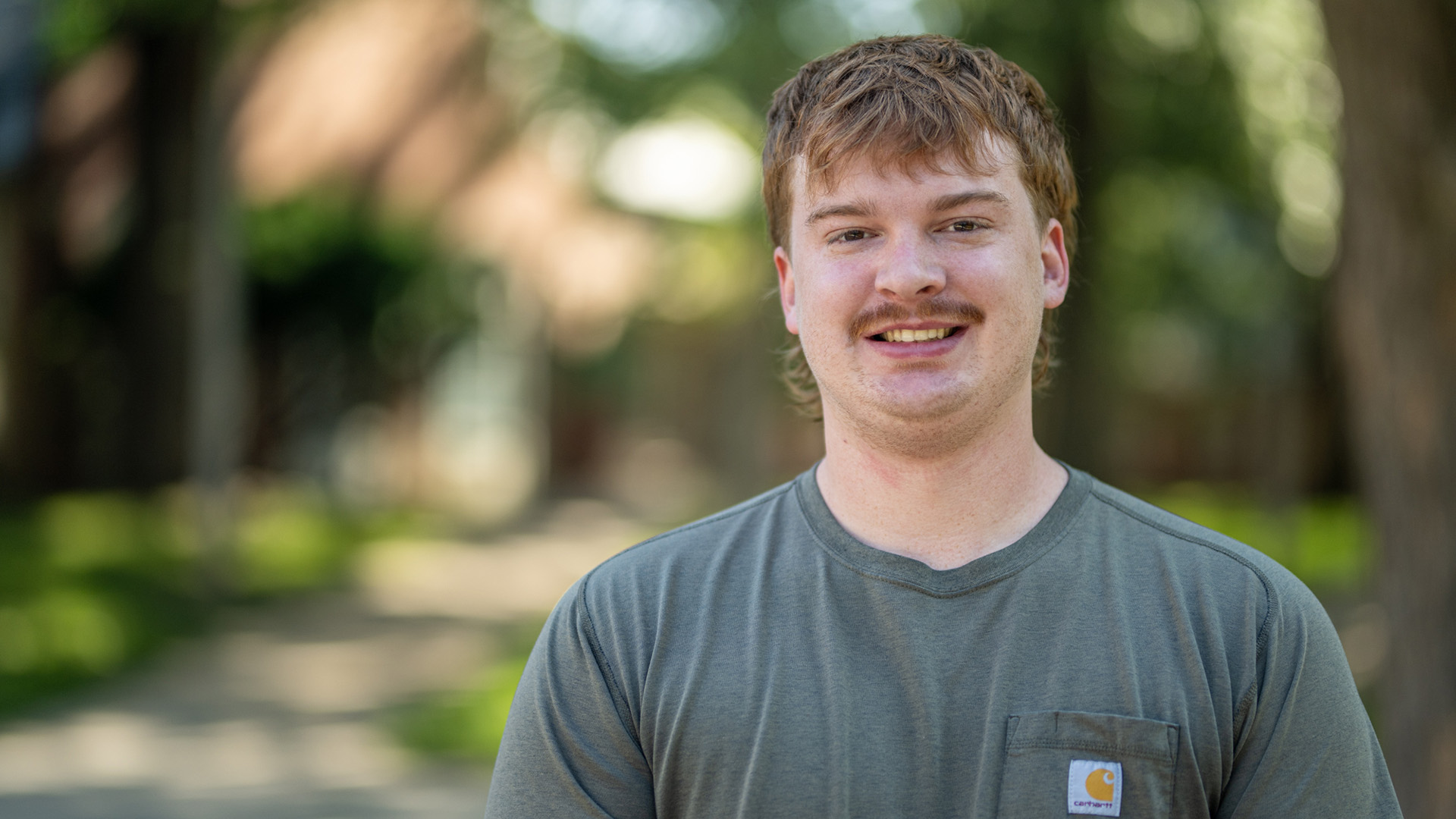 a man stands outdoors on the university of iowa campus