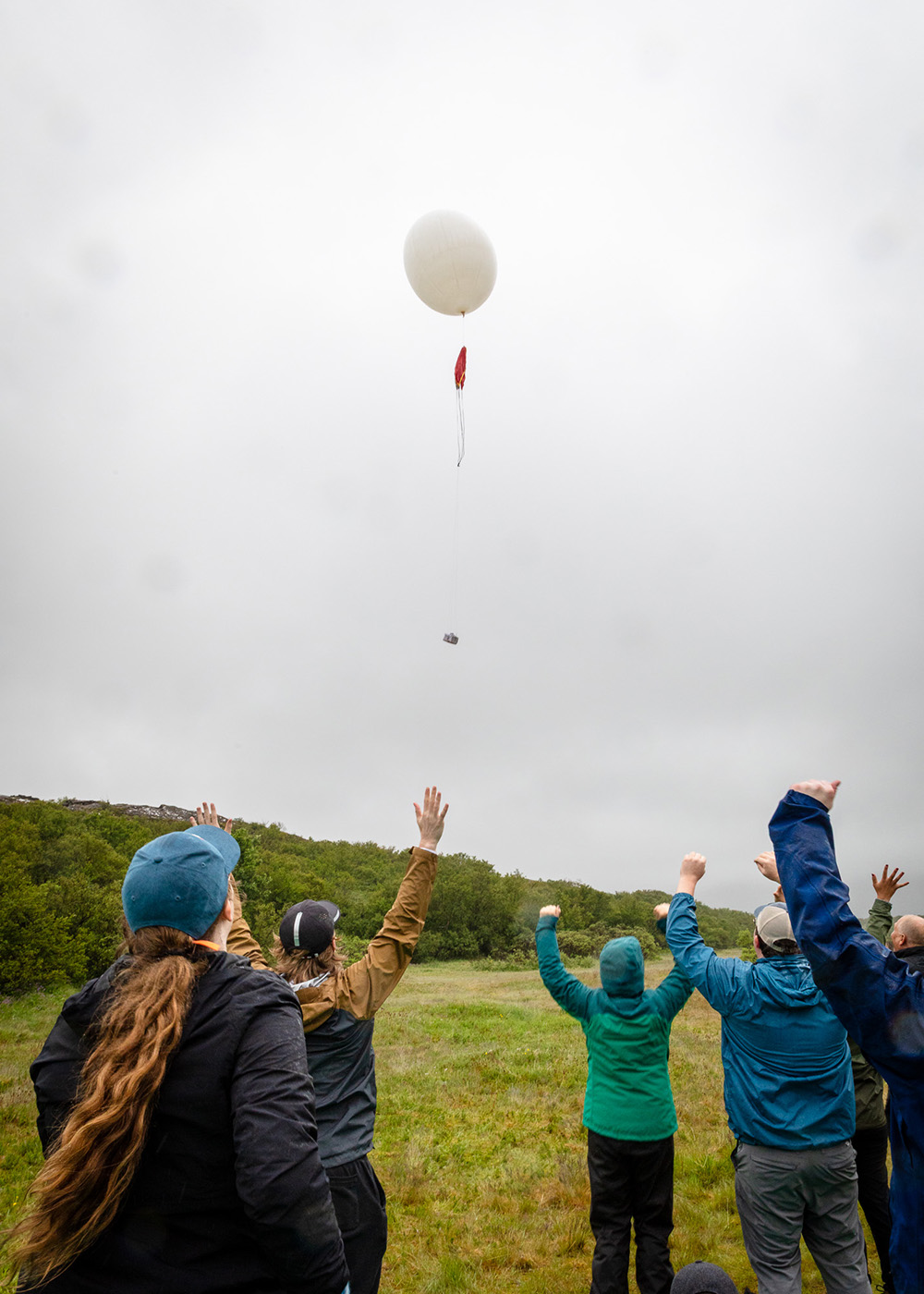 University of Iowa students raise their hands in celebration as a balloon takes flight in Iceland