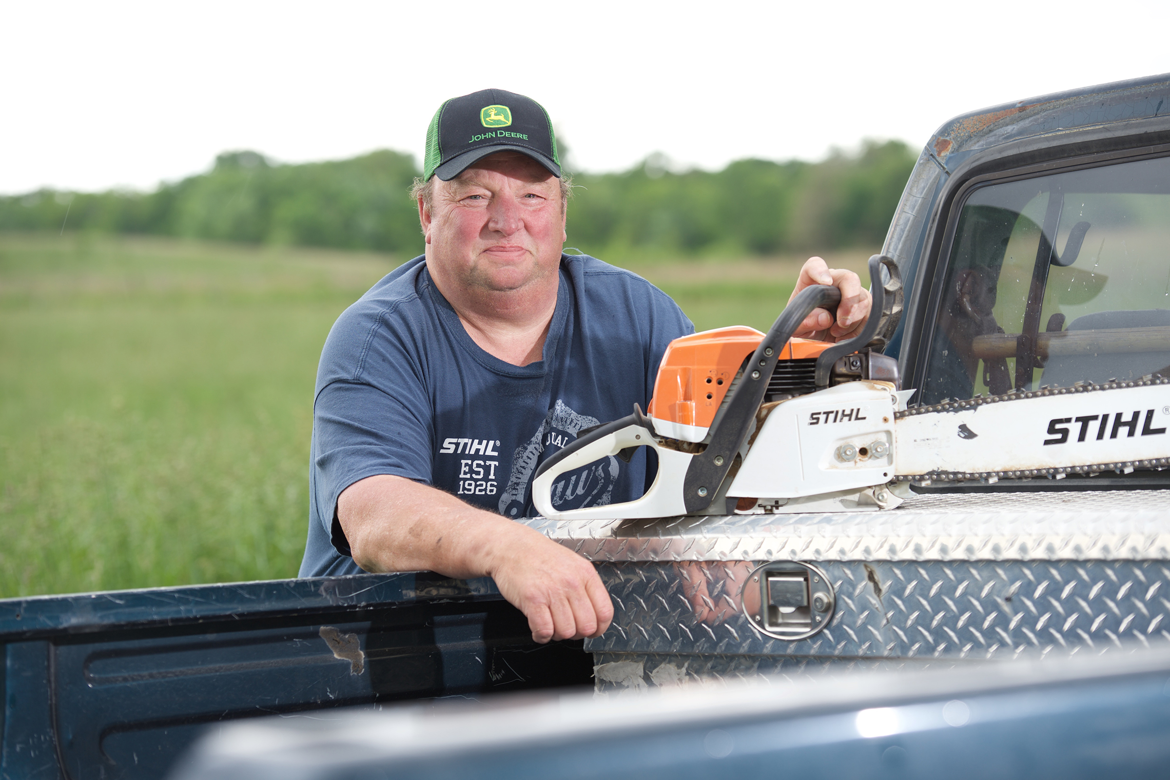 Stephen Boeding standing by his truck with a chain saw