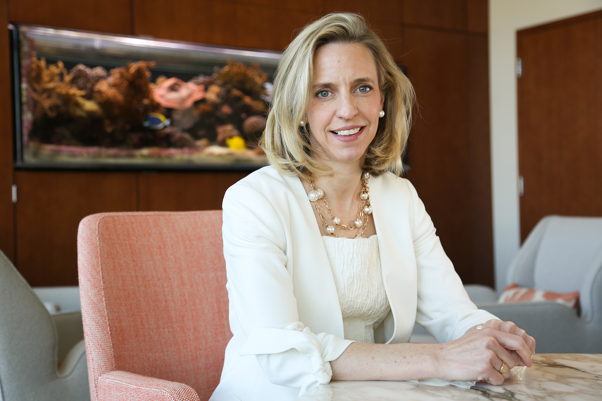 University of Iowa alumna Bridget Coughlin sitting in an office with an aquarium in the background