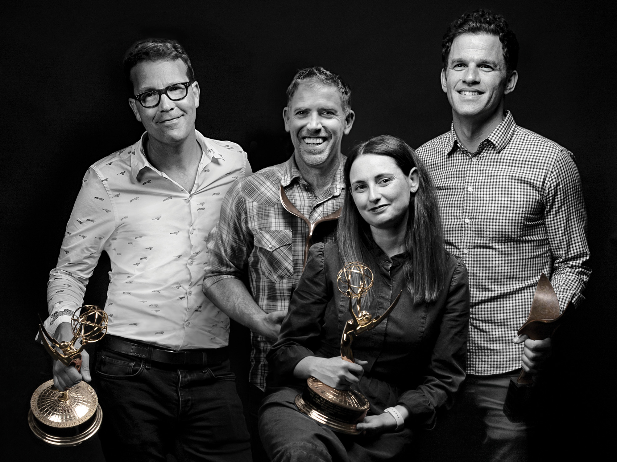 the four writers of Castle Rock pose together for a photo, two of them holding award statues