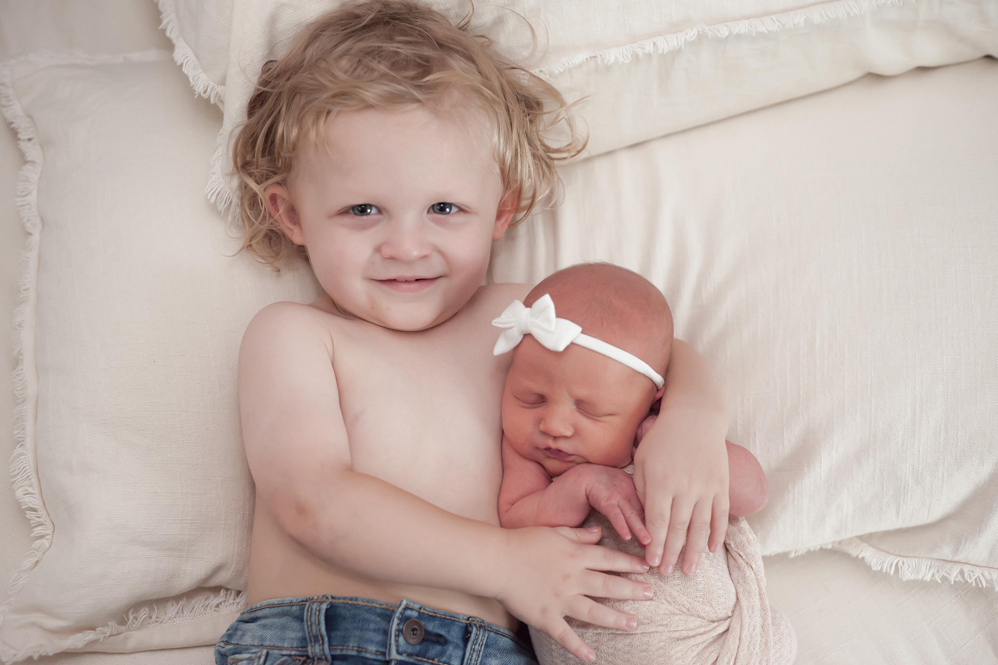 two young siblings lying next to each other