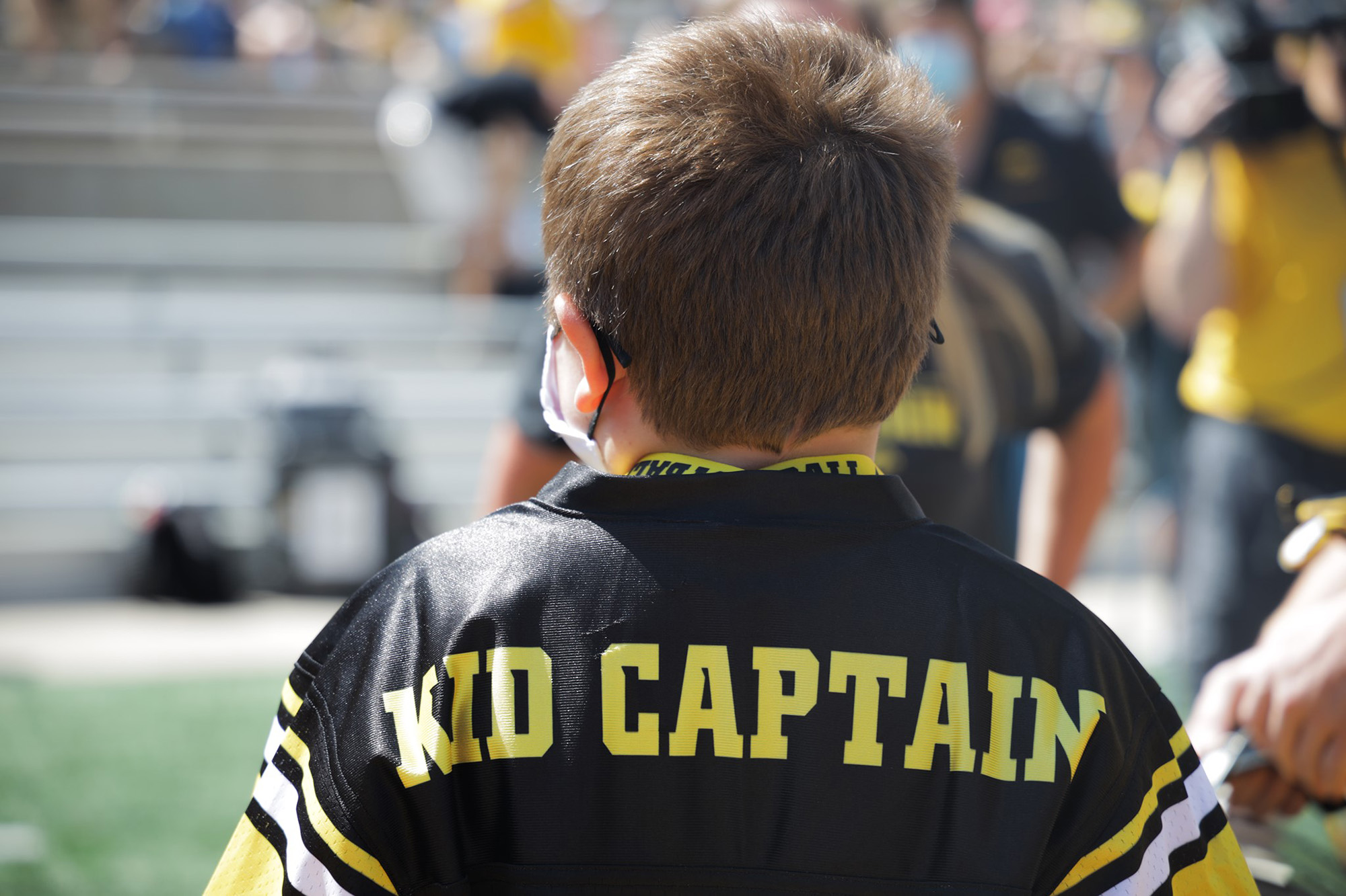 a child wearing an Iowa jersey that says Kid Captain on the nameplate