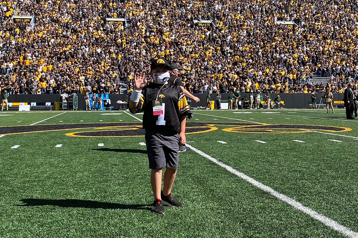 Kid Captain Bentley Steven waves to fans at Kinnick Stadium