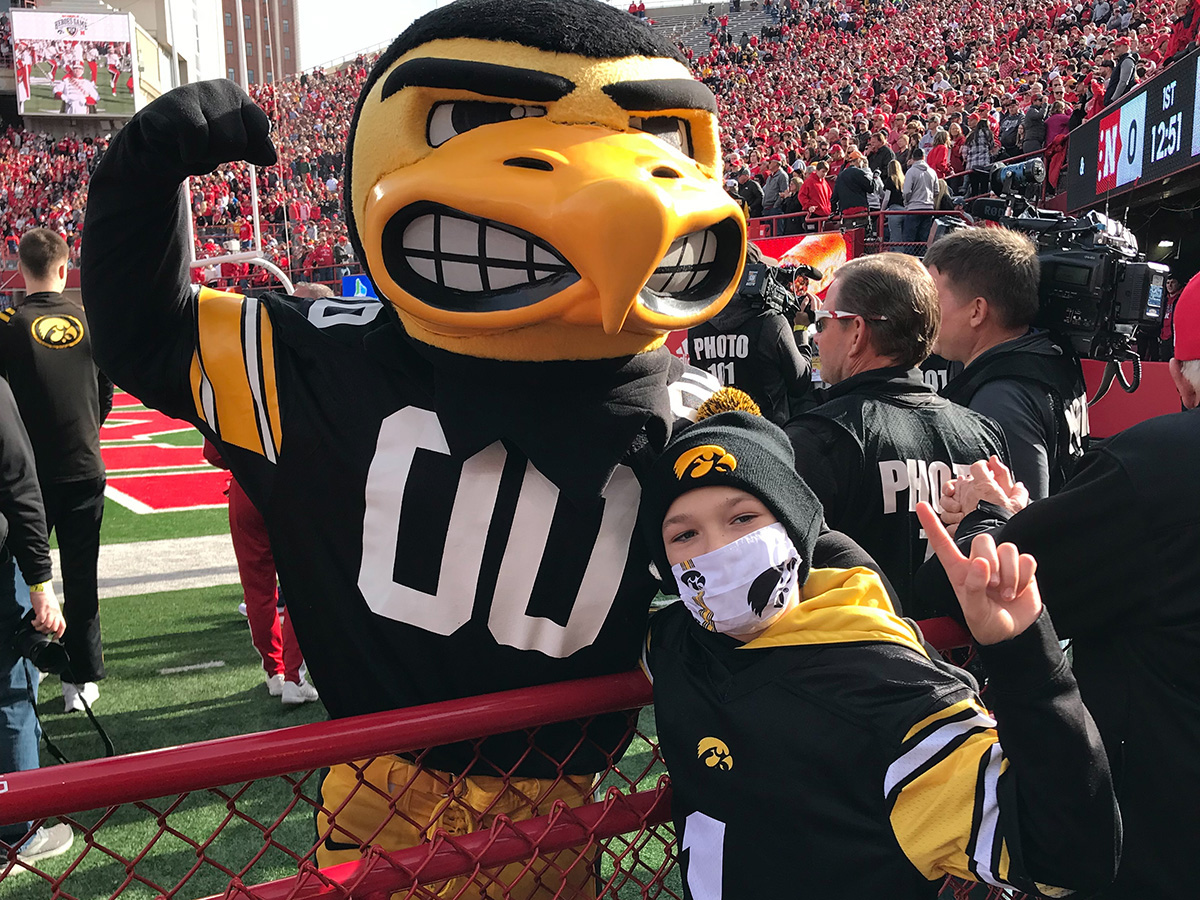 Kid Captain Blake Burdorf posing with Herky during the Iowa Hawkeyes football game at Nebraska