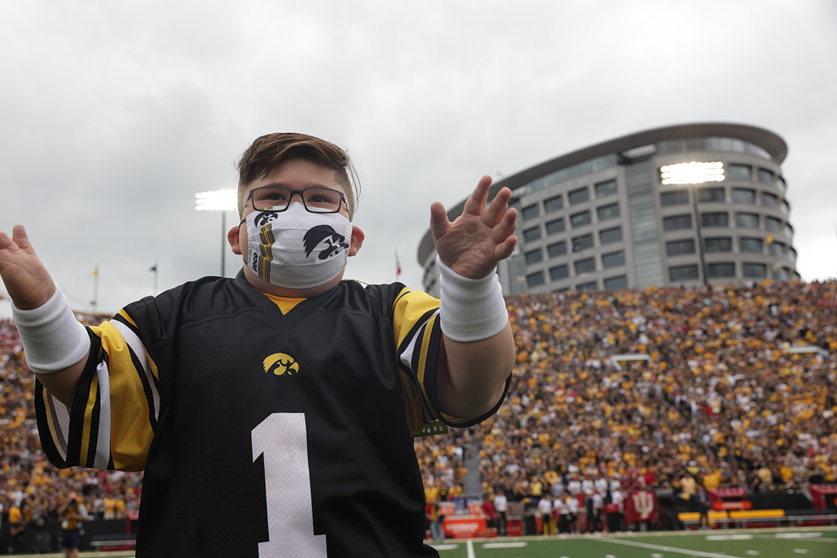 Kid Captain Drew Hennigan cheers on the field at Kinnick Stadium