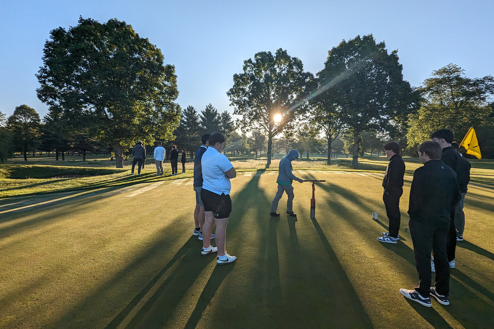 students preparing a golf course for a tournament