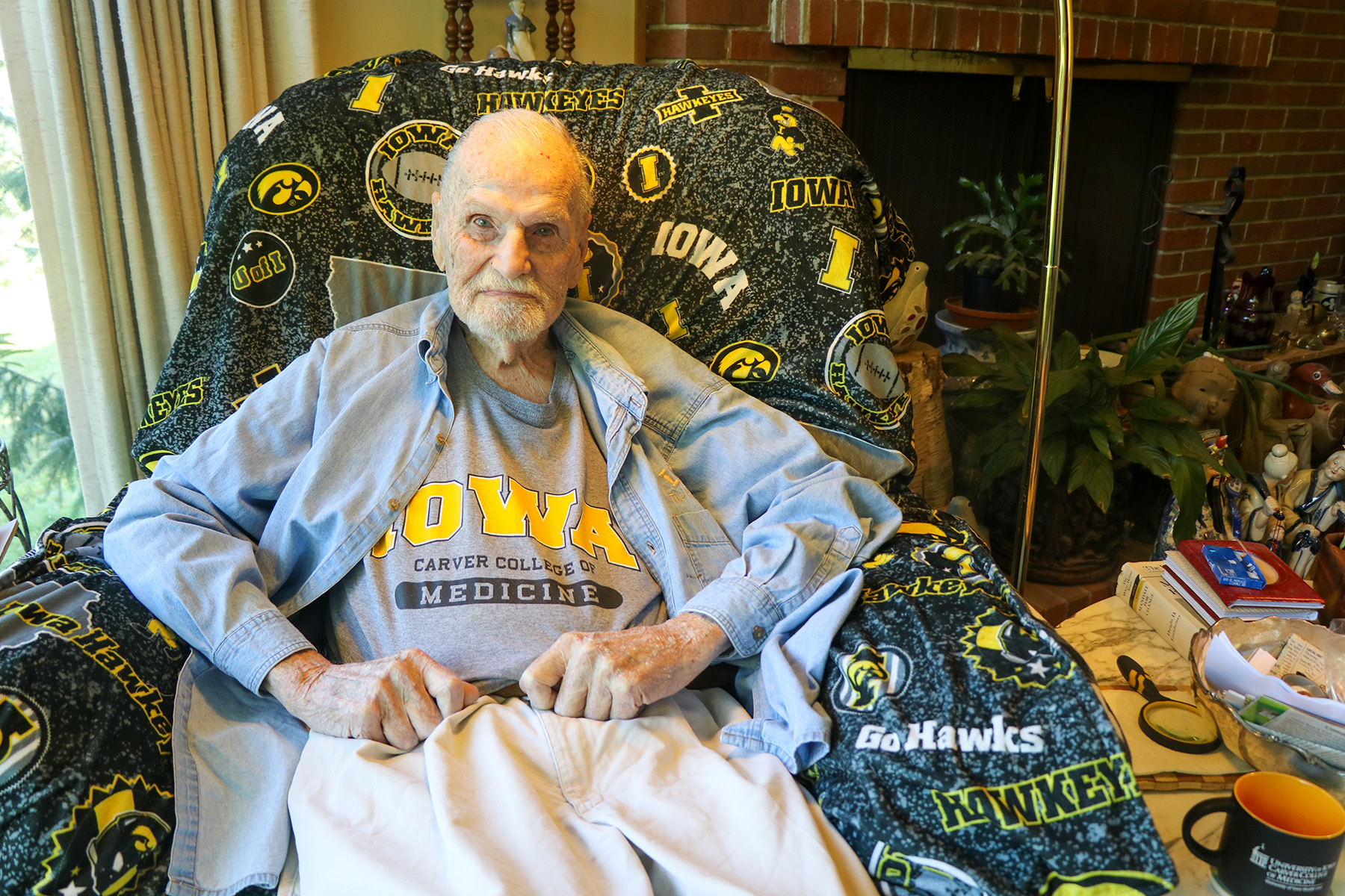 university of iowa carver college of medicine alum rufus kruse sitting in his home wearing an alum t-shirt