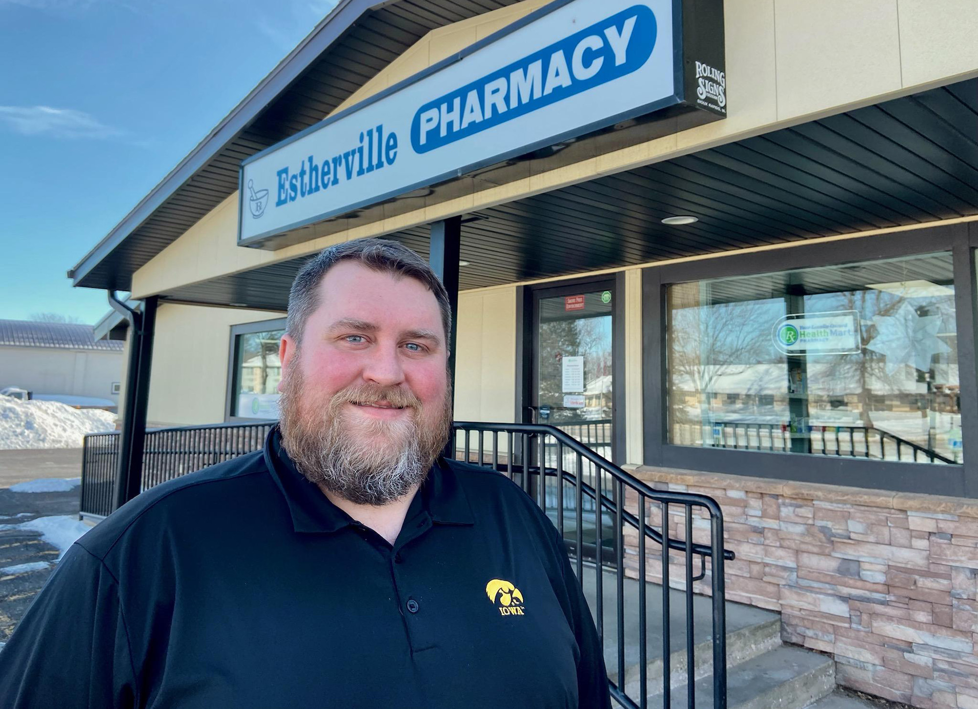 a man standing outside his pharmacy