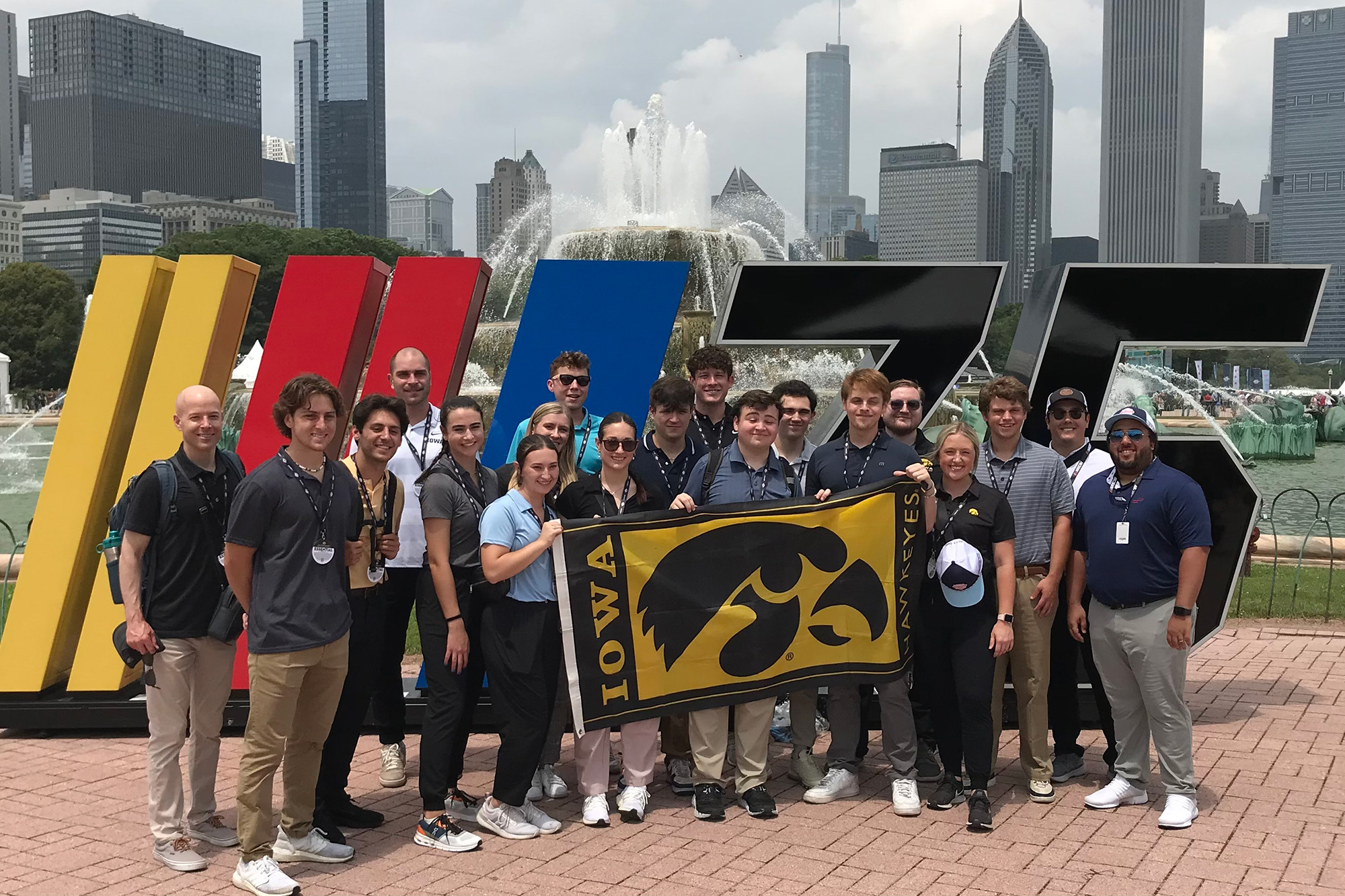 University of Iowa students posing for photo in Chicago, holding a flag with a Tiger hawk