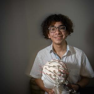 Student sitting at desk with brain model