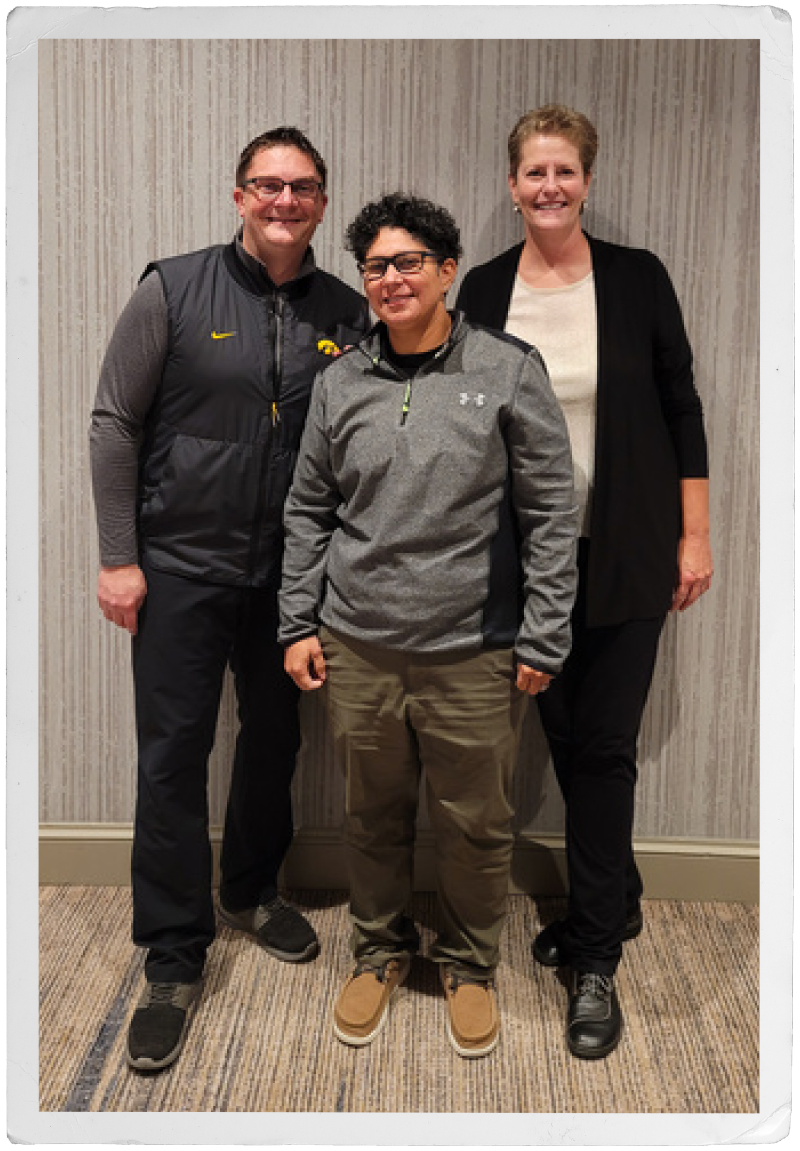 a man and two women who work in law enforcement pose together in a hallway