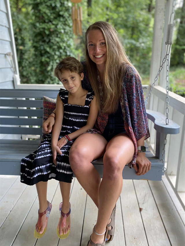 Alivia Linnekin and Michaela Heys sitting together on a porch swing