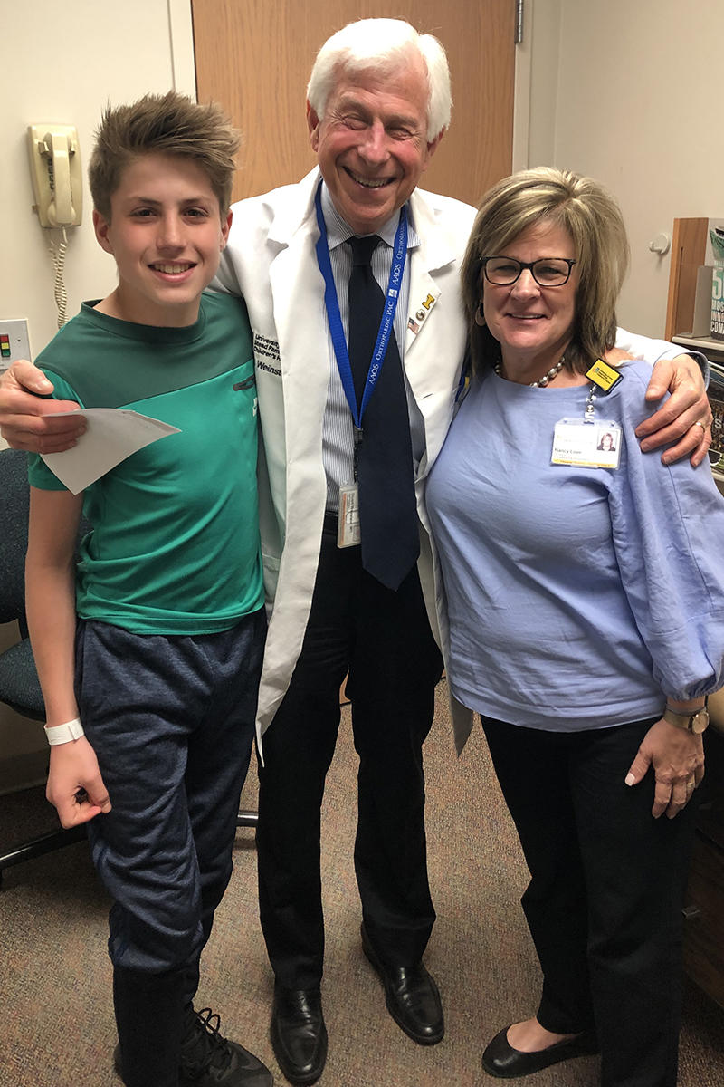 Will Imbus, Stuart Weinstein, and Nancy Love posing for a group photo during one of Will's follow-up visits to UI Stead Family Children's Hospital