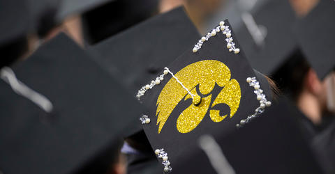 graduation caps at a commencement ceremony, one with a tigerhawk logo
