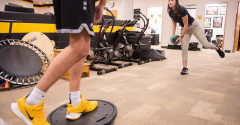University of Iowa athletic training student Zoe Hicks works with a basketball player