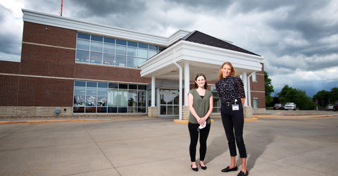 two graduates of The University of Iowa College of Nursing’s nurse practitioner programs stand outside a health care facility