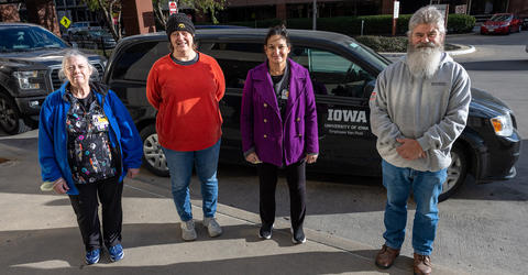 four University of Iowa Health Care employees standing in front of a van