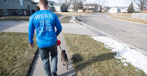 a man walking his dog through a neighborhood