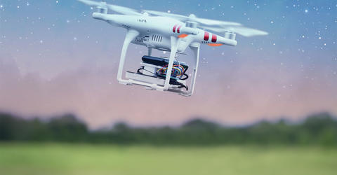 a drone flying amid a star-filled sky in a grassy and wooded landscape