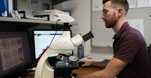 University of Iowa doctoral student Matt McGregor works at a desk in a lab