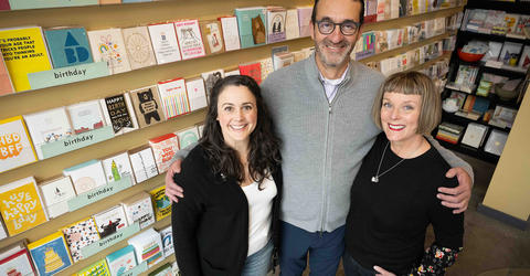 two women and one man stand in a card and stationery shop