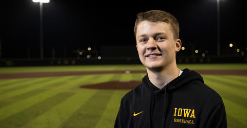 University of Iowa graduate Reed Zahradnik standing near home plate at Banks Field, the University of Iowa baseball facility