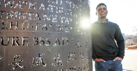 University of Iowa student James McCurtis III stands near a sculpture outside the journalism building