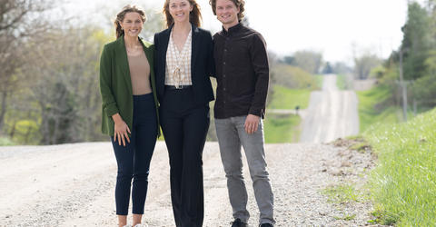 three University of Iowa public health students standing on a rural road