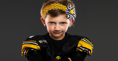 university of iowa stead family children's hospital patient and kid captain harper stribe posing in hawkeye jersey