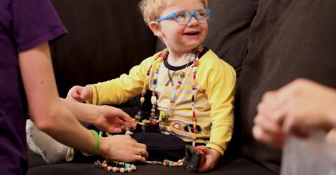 a young boy who received bone marrow transplant at the UI Stead Family Children's Hospital is shown wearing a necklace that symbolizes all the procedures he's had to endure